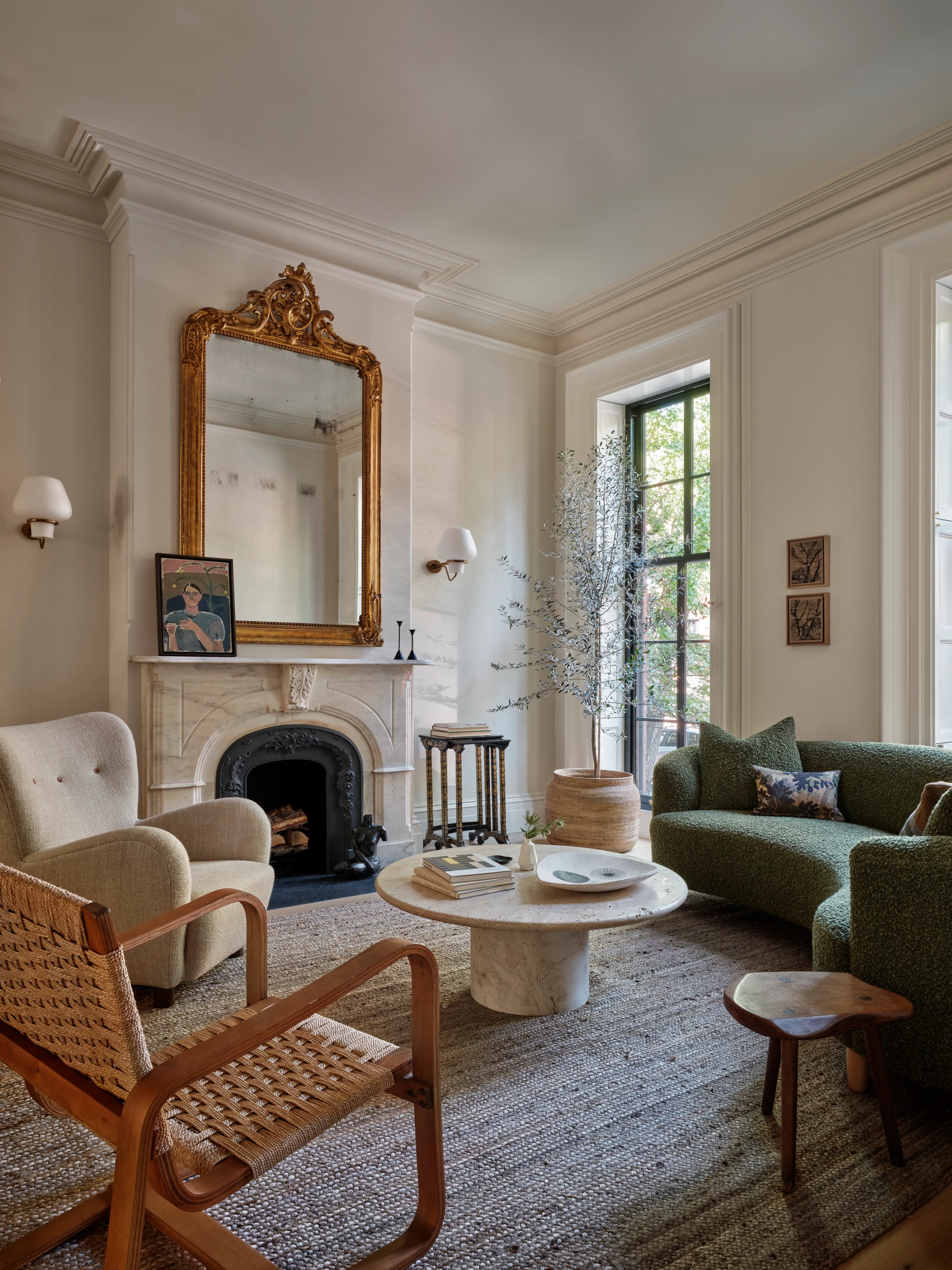 The green plaster-clad family room below the kitchen uses low furniture, warm oak, and filtered light to keep the rear addition grounded.