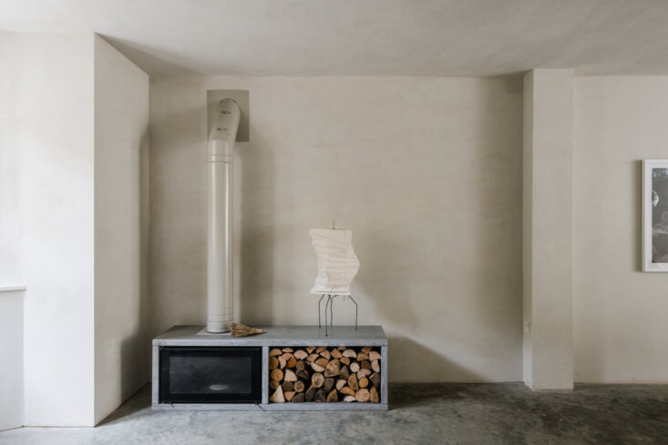 In the den, a Stovax wood-burning stove is set into a custom polished-concrete surround with open log storage.
