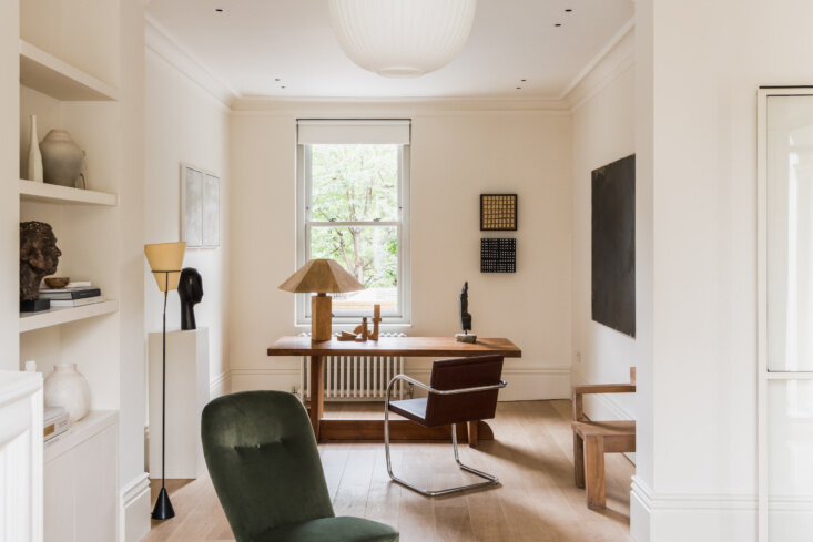 Looking through the reception room, an Axel Einar Hjorth Lovo table serves as a desk beside a chrome cantilever chair.